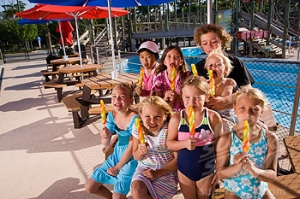 Children eating lollipop in water park